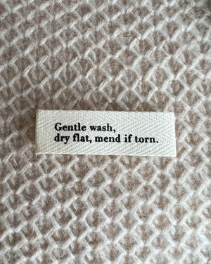 "GENTLE WASH, DRY FLAT, MEND IF TORN."-LABEL